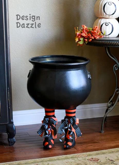 Make an unusual Halloween prop for your decor! Add witch's boots to a plastic cauldron for a Boot-a-licious Halloween decor! - Design Dazzle