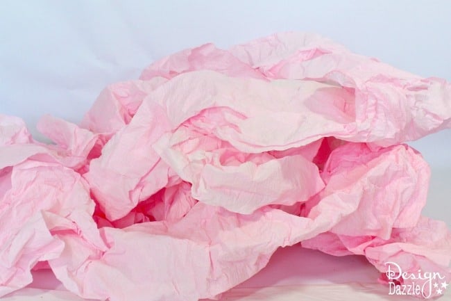 Step-by-step tutorial of how to transform a roll or paper towel to a fabulous paper ruffle garland on designdazzle.com! #DIYfairyparty #DIYpartydecor #papertowelgarland