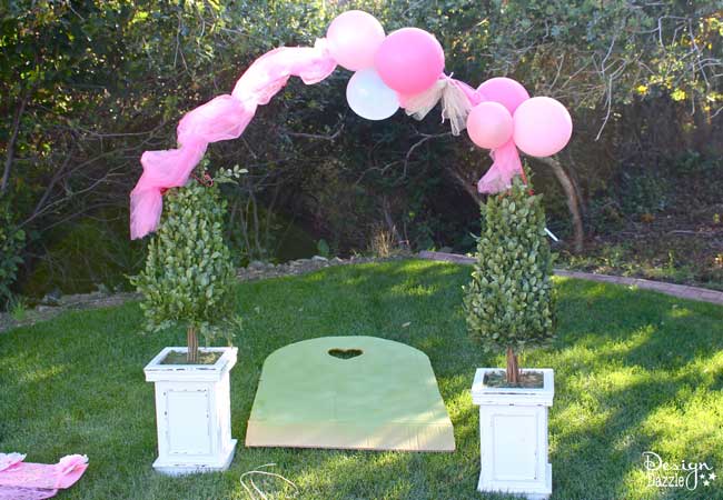 Balloons And Flowers Make a Beautiful Fairy Arch. Tutorial on how to use balloons and dollar store flowers to create this beautiful show stopper party decor on a budget! Design Dazzle #fairyparty #DIYfairyparty #balloonflowerarch