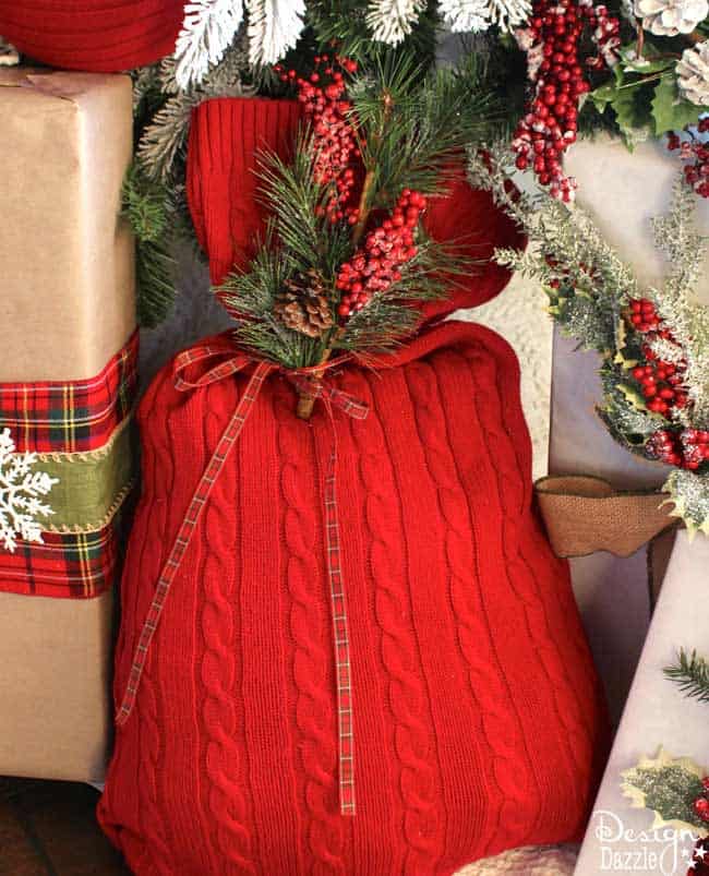 Repurpose an old sweater into a gift bag. Love the warm cozy look this sweater brings to our Christmas decor. Reuse it every year to wrap gifts. Use the glue gun or sew it! Design Dazzle #repurposed