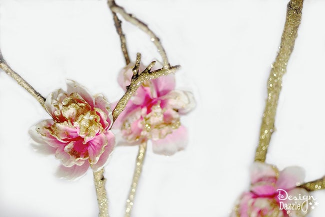 Creating a fairy party on a budget. How to make a fairy branch centerpiece using glitter, dollar store flowers and a free tree branch. Design Dazzle