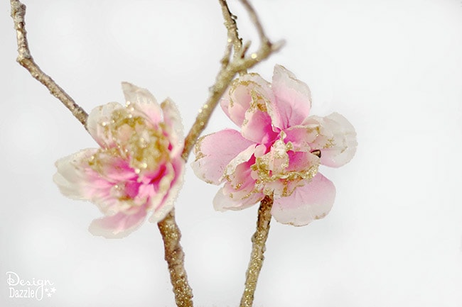 Creating a fairy party on a budget. How to make a fairy branch centerpiece using glitter, dollar store flowers and a free tree branch. Design Dazzle