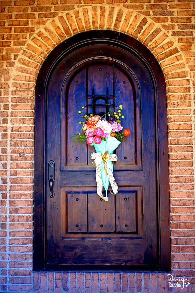 Repurpose an old umbrella for some beautiful spring door decor on Design Dazzle! #diydecor #springdecor