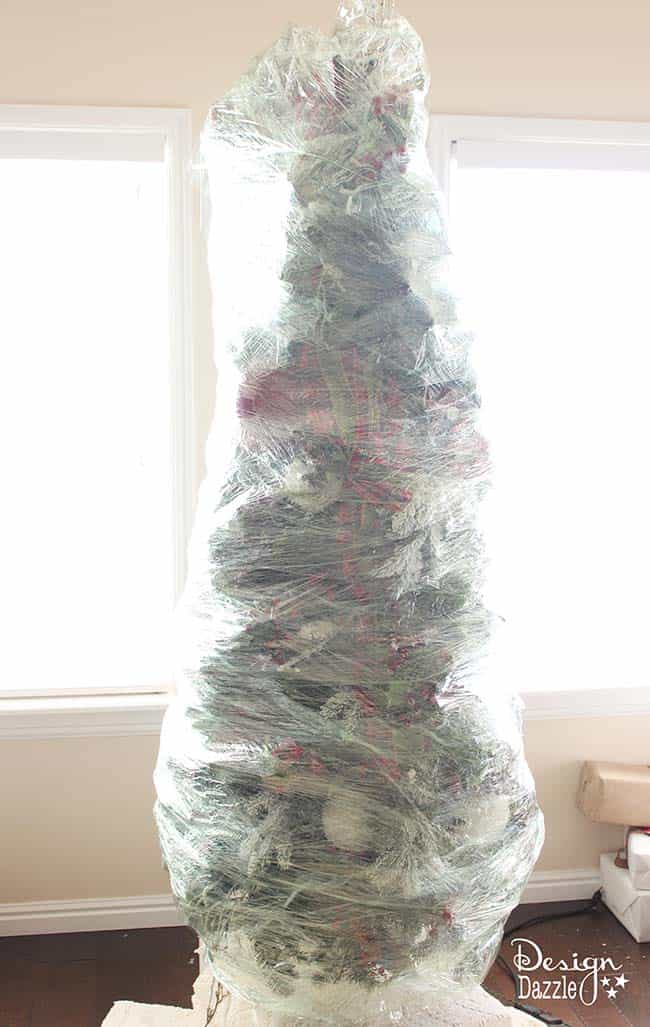 This year, wrap up your Christmas tree for easy storage! The BEST Christmas decorating and time-saving tip ever!! Wrap up your artificial DECORATED Christmas tree and store for next year. No putting away your ornaments and taking down the tree. LOVE this idea! Design Dazzle