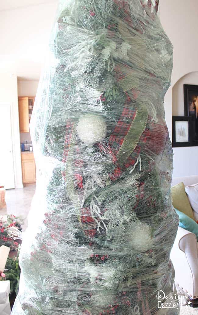 This year, wrap up your Christmas tree for easy storage! The BEST Christmas decorating and time-saving tip ever!! Wrap up your artificial DECORATED Christmas tree and store for next year. No putting away your ornaments and taking down the tree. LOVE this idea! Design Dazzle