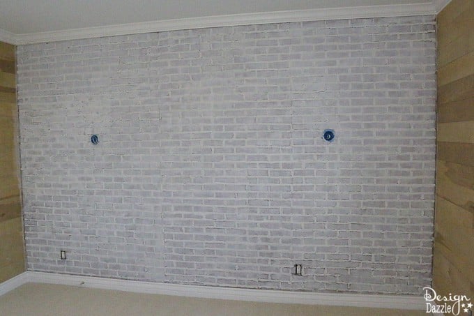 This post shows how to take fake brick wall paneling and turn it into a real looking, white washed brick wall! The perfect solution if you're on a budget. | Design Dazzle
