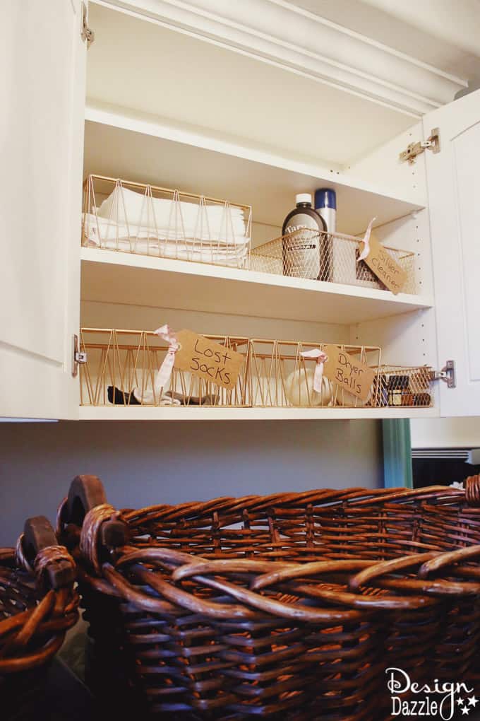 I'm showing you how to take your laundry room cabinet organization from drab to fab while on a budget! You will love these rose gold metal baskets! | Design Dazzle