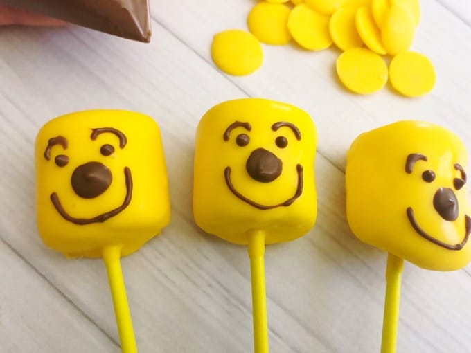 Make these pooh bear marshmallow pops in minutes! So easy and quick to make and super fun too! The kids will definitely enjoy making AND munching on them! - Design Dazzle