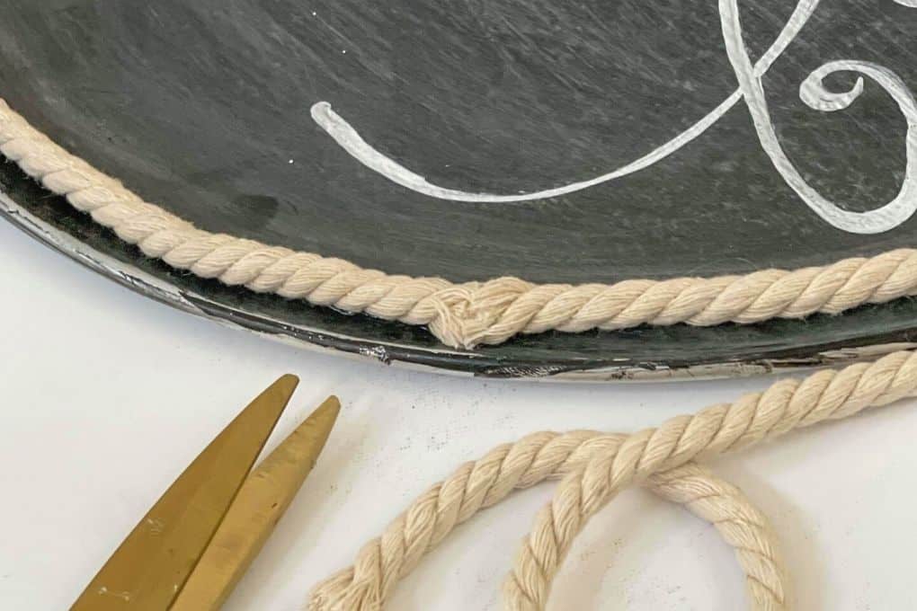 Glue cord trim to pizza pan wreath