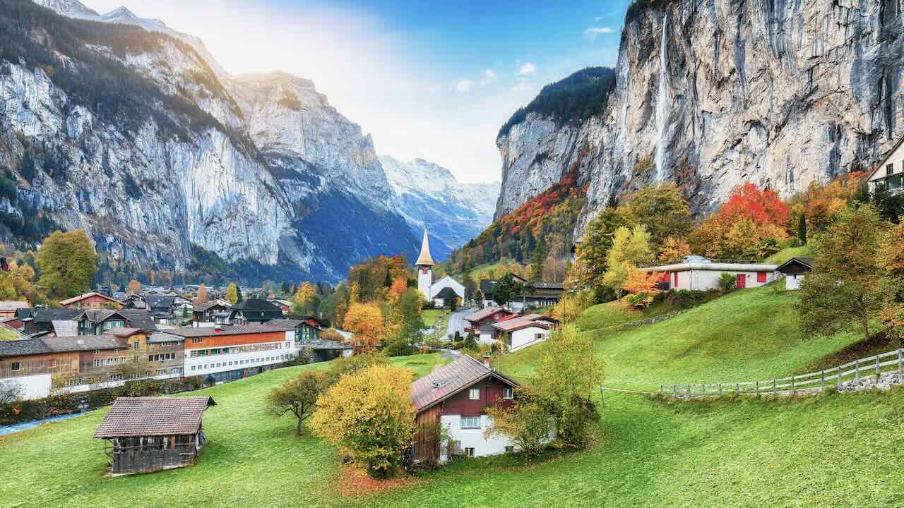 Captivating autumn view of Lauterbrunnen valley with gorgeous Staubbach waterfall and Swiss Alps in the background